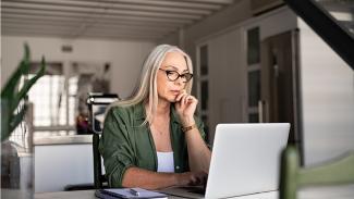 Woman thinking by the laptop